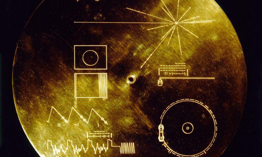 This gold aluminum cover was designed to protect the Voyager 1 and 2 "Sounds of Earth" gold-plated records from micrometeorite bombardment, but also serves a double purpose in providing the finder a key to playing the record. The explanatory diagram appears on both the inner and outer surfaces of the cover, as the outer diagram will be eroded in time. Flying aboard Voyagers 1 and 2 are identical "golden" records, carrying the story of Earth far into deep space. The 12 inch gold-plated copper discs contain greetings in 60 languages, samples of music from different cultures and eras, and natural and man-made sounds from Earth. They also contain electronic information that an advanced technological civilization could convert into diagrams and photographs.